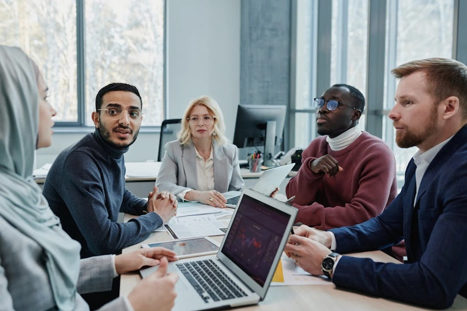 Uśmiechnięty zespół Akademii Doświadczonych podczas spotkania w biurze.
